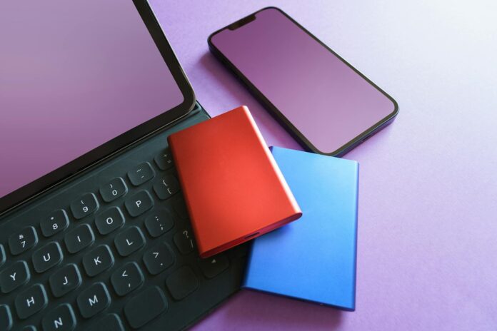 Colorful gadgets including a smartphone, tablet, and SSD on a purple background, ideal for tech-themed projects.